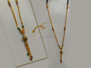 Close-up image of a traditional Indian gold-plated mangalsutra featuring black beads, green and pink stones, and a designer pendant with hanging chains.