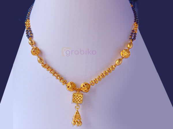 Gold-plated mangalsutra with a modern design, black beads, green and red gemstones, and a hanging golden tassel pendant.