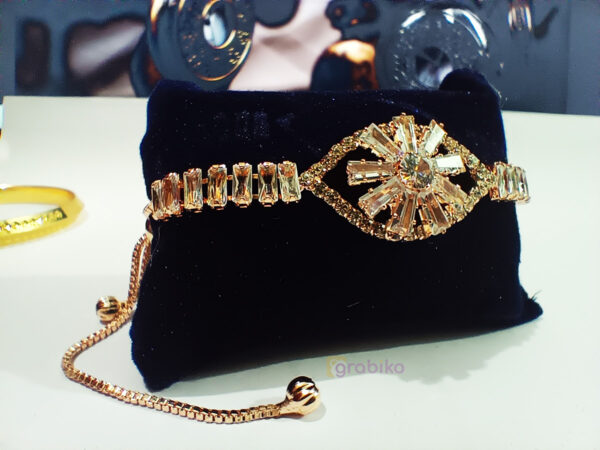 Gold-tone starburst bracelet for women with clear crystal baguettes on adjustable chain – stylish fashion jewelry by Grabiko.