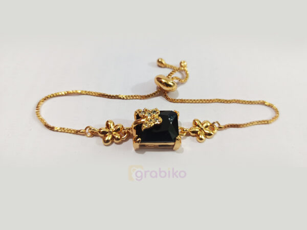 Gold-plated adjustable bracelet with black stone centerpiece and floral charms