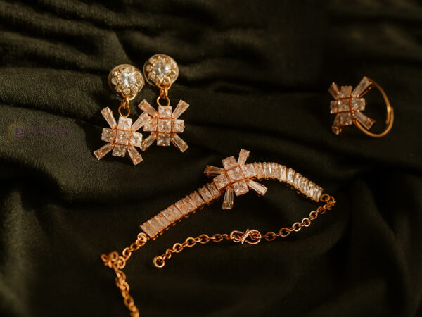 Rose gold jewelry set with snowflake design earrings, bracelet, and ring adorned with cubic zirconia stones