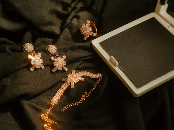 Rose gold jewelry set with snowflake design earrings, bracelet, and ring adorned with cubic zirconia stones