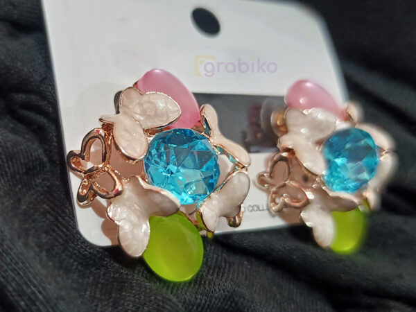 Vibrant floral earrings with blue crystal centerpiece and pink, green, and white accents