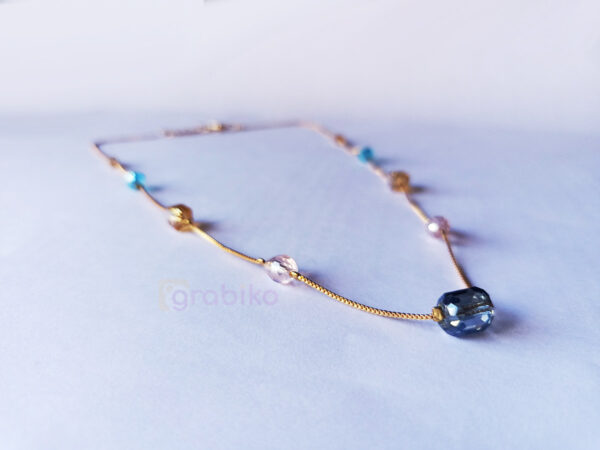 Elegant gold chain necklace with multicolor beads on a white background.