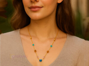 Elegant gold chain necklace with multicolor beads on a white background.