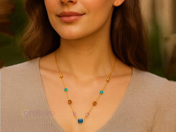 Elegant gold chain necklace with multicolor beads on a white background.