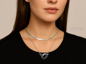 Double-layer silver necklace with snake chain, link chain, and interlocking ring pendant with crystals.