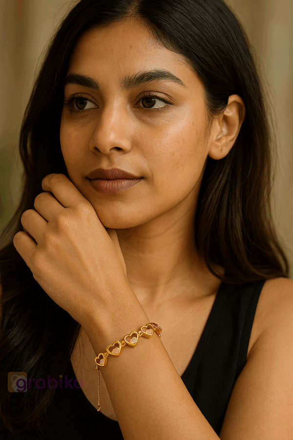 Gold bracelet featuring interlinked heart shapes with cubic zirconia stones on velvet display